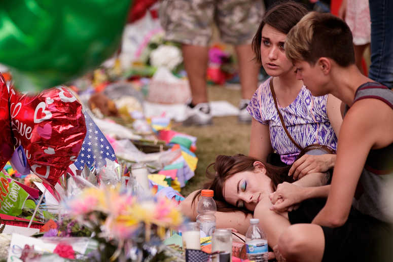 A group of young women grieve at a memorial site for the victims of the Pulse Nightclub shooting, June 15, 2016 in Orlando, Florida. (Photo by Drew Angerer/Getty Images)