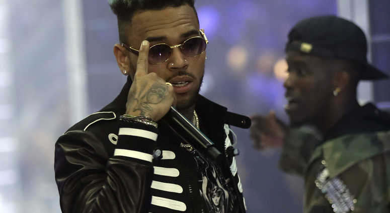 Two police officials say U.S. singer Chris Brown and two other people are in custody in Paris after a woman filed a rape complaint. Chris Brown