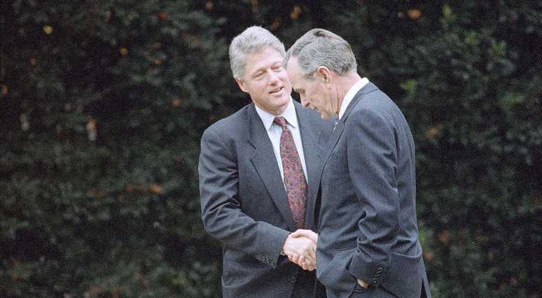 In this Nov. 18, 1992 file photo, President George H.W. Bush shakes hands with President-elect Bill Clinton after an Oval Office meeting in Washington. Clinton and Bush