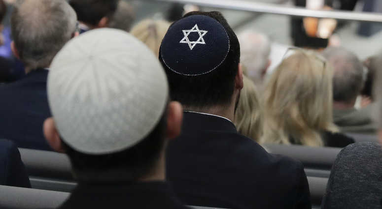 Two men wearing skullcaps as they listen to the speech of Israeli Historian Saul Friedlaender. Skullcap