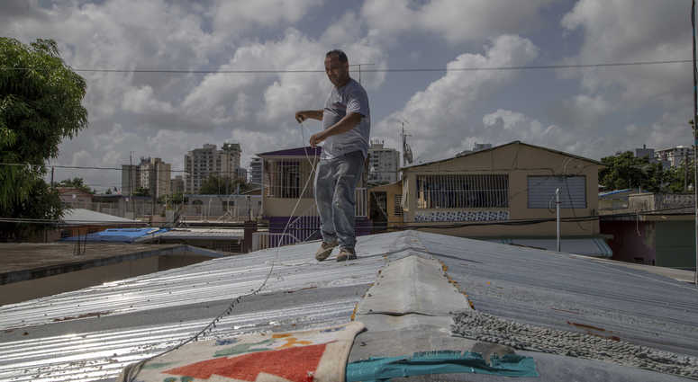 Jorge Ortiz works to tie down his roof as he prepares for the arrival of Tropical Storm Dorian, in the Martín Peña neighborhood of San Juan, Puerto Rico, Tuesday, Aug. 27, 2019. The construction worker was taking no chances as Dorian approaches. Jorge Ortiz works to tie down his roof as he prepares for the arrival of Tropical Storm Dorian, in the Martín Peña neighborhood of San Juan, Puerto Rico, Tuesday, Aug. 27, 2019. The construction worker was taking no chances as Dorian approaches.
