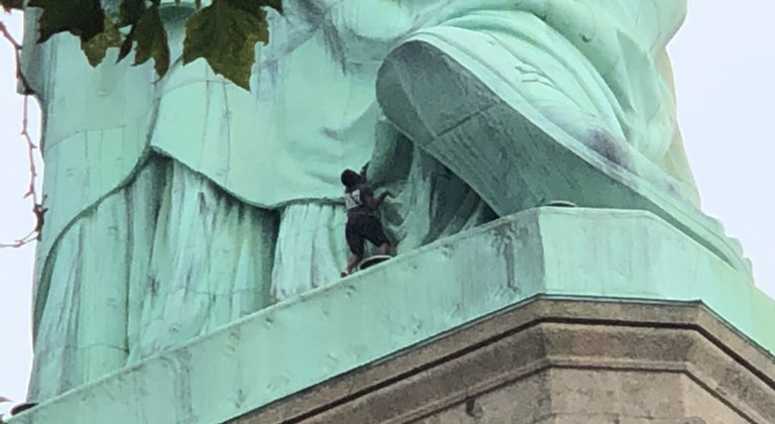 Woman attempting to climb the Statue of Liberty. Statue Of Liberty Climber