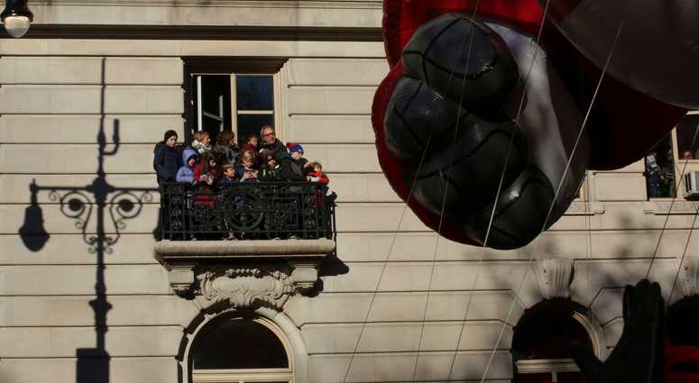 People on a balcony watch the 92nd annual Macy's Thanksgiving Day Parade on November 22, 2018 in New York City. Thanksgiving Day Parade 2018