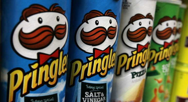 Packages of Pringles potato chips are displayed on a shelf at a market. pringles