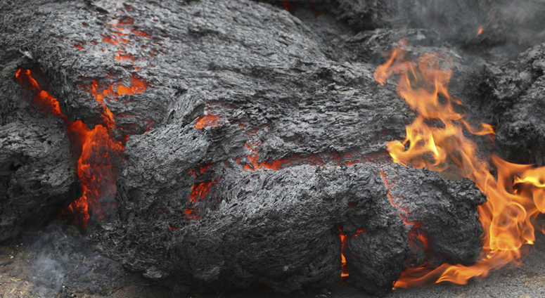 In this May 5, 2018, file photo, lava burns across a road in the Leilani Estates subdivision near Pahoa, Hawaii. The lava hisses, crackles and pops. It roars like an engine as it sloshes and bubbles. In this May 5, 2018, file photo, lava burns across a road in the Leilani Estates subdivision near Pahoa, Hawaii. The lava hisses, crackles and pops. It roars like an engine as it sloshes and bubbles.