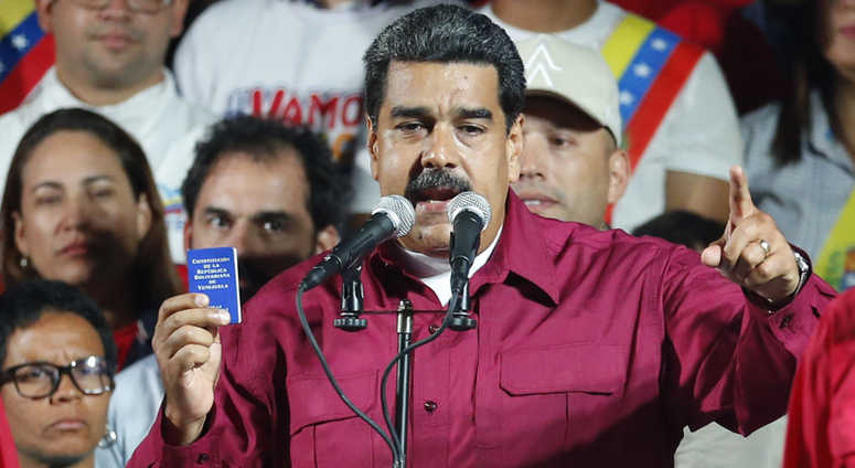 Venezuela's President Nicolas Maduro places his fist against his heart as he arrives with his wife Cilia Flores to address supporters from the presidential palace. Venezuela's President Nicolas Maduro places his fist against his heart as he arrives with his wife Cilia Flores to address supporters from the presidential palace.