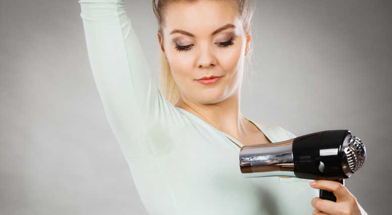 Woman drying wet armpit using hair dryer. Woman drying wet armpit using hair dryer.