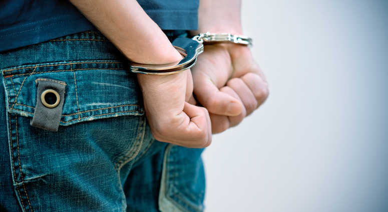 Teenager in handcuffs. Teenager in handcuffs.