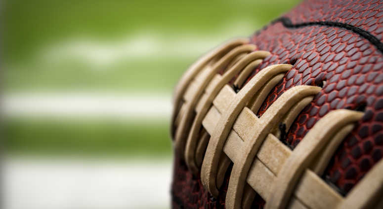 Macro of a vintage worn american football ball with visible laces, stitches and pigskin pattern Macro of a vintage worn american football ball with visible laces, stitches and pigskin pattern