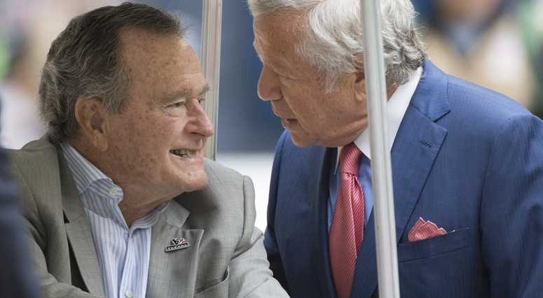 New England Patriots' owner Robert Kraft, right, talks with former U.S. President George H.W. Bush before the start of an NFL game between the Patriots and the Houston Texans on Sunday, Dec. 1, 2013, in Houston, Texas. George H.W. Bush
