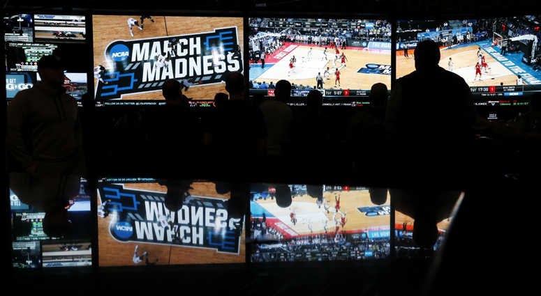 In this March 15, 2018 photo, people watch coverage of the first round of the NCAA college basketball tournament at the Westgate Superbook sports book in Las Vegas. In this March 15, 2018 photo, people watch coverage of the first round of the NCAA college basketball tournament at the Westgate Superbook sports book in Las Vegas.