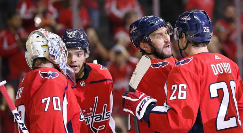 Members of the Washington Capitals talk on the ice. Washington_Capitals