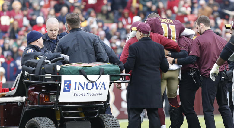 Redskins trainers help quarterback Alex Smith onto a cart. Alex_Smith_Injury