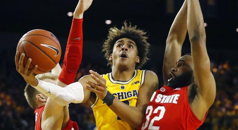 Michigan guard Jordan Poole (2) scores between Ohio State forward Justin Ahrens, left, and guard Keyshawn Woods during the second half of an NCAA college basketball game Tuesday, Jan. 29, 2019, in Ann Arbor, Mich. (AP Photo/Carlos Osorio) Michigan guard Jordan Poole (2) scores between Ohio State forward Justin Ahrens, left, and guard Keyshawn Woods during the second half of an NCAA college basketball game Tuesday, Jan. 29, 2019, in Ann Arbor, Mich. (AP Photo/Carlos Osorio)