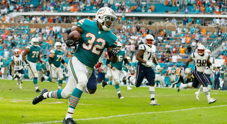 MIAMI, FL - DECEMBER 09: Kenyan Drake #32 of the Miami Dolphins carries the ball for the game winning touchdown defeating the New England Patriots 34-33 at Hard Rock Stadium on December 9, 2018 in Miami, Florida. (Photo by Michael Reaves/Getty Images) MIAMI, FL - DECEMBER 09: Kenyan Drake #32 of the Miami Dolphins carries the ball for the game winning touchdown defeating the New England Patriots 34-33 at Hard Rock Stadium on December 9, 2018 in Miami, Florida. (Photo by Michael Reaves/Getty Images)