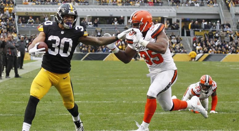 Pittsburgh Steelers running back James Conner (30) scores a touchdown past Cleveland Browns defensive end Myles Garrett (95) during the third quarter at Heinz Field. The Steelers won 33-18. James Conner of the Pittsburgh Steelers stiff-arms Myles Garrett of the Cleveland Browns
