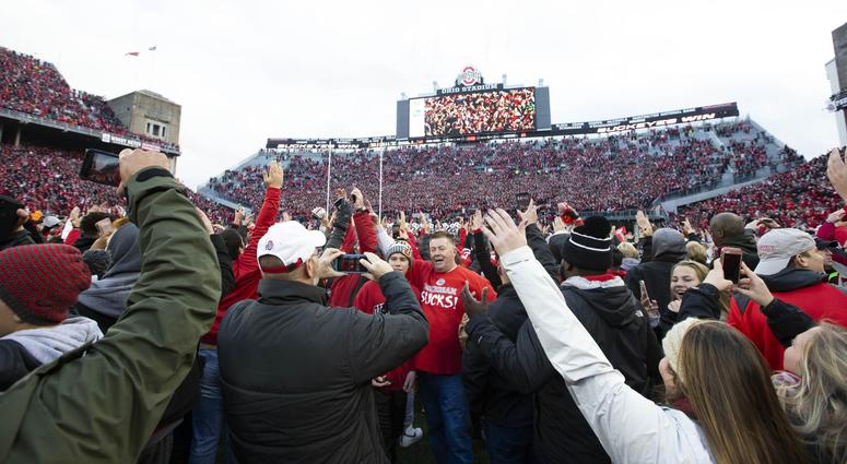 Ohio State Buckeyes fans swarm the field after a victory over the Michigan Wolverines at Ohio Stadium.