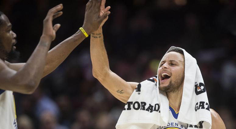 Golden State Warriors guard Stephen Curry (30) celebrates with forward Kevin Durant (35) during the second half against the Cleveland Cavaliers at Quicken Loans Arena.