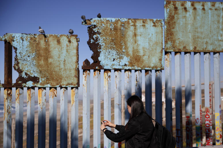 Una mujer toma fotos de un tramo herrumbrado del muro fronterizo entre EEUU y México cerca de Tijuana, México, el 7 de enero del 2019. Una mujer toma fotos de un tramo herrumbrado del muro fronterizo entre EEUU y México cerca de Tijuana, México, el 7 de enero del 2019.