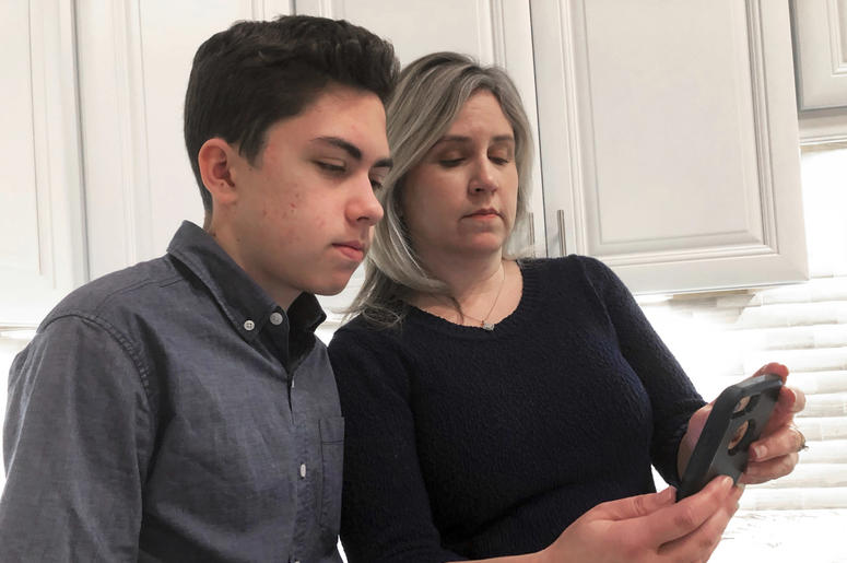 Fotografía de archivo del 31 de enero de 2019 de Gran Thompson y su madre, Michele, mientras ven un iPhone en la cocina de su casa en Tucson, Arizona. Fotografía de archivo del 31 de enero de 2019 de Gran Thompson y su madre, Michele, mientras ven un iPhone en la cocina de su casa en Tucson, Arizona.