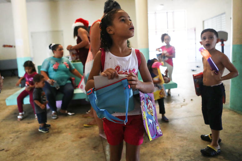 TOA BAJA, PUERTO RICO - DECEMBER 25: Janellise Rivera (C), whose family lost their home in Hurricane Maria, waits to receive a Christmas present from a church group in a shelter for Hurricane Maria victims on December 25, 2017 in Toa Baja, Puerto Rico. 12 TOA BAJA, PUERTO RICO - DECEMBER 25: Janellise Rivera (C), whose family lost their home in Hurricane Maria, waits to receive a Christmas present from a church group in a shelter for Hurricane Maria victims on December 25, 2017 in Toa Baja, Puerto Rico. 12