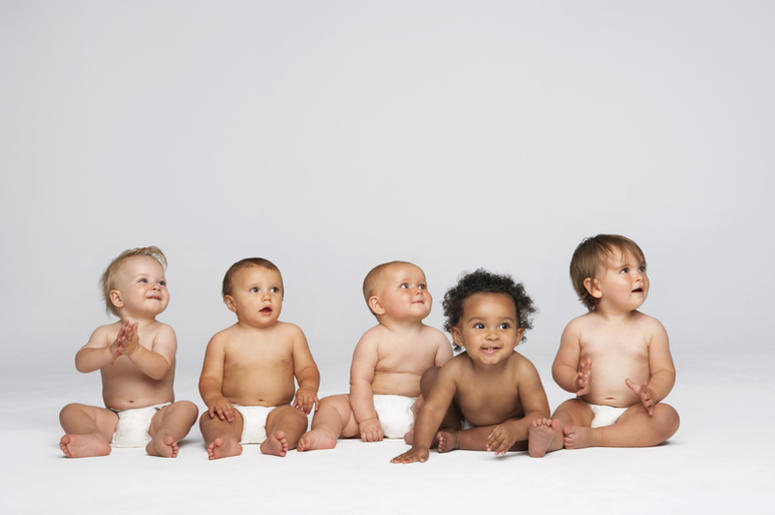 group of babies in diapers against a light background