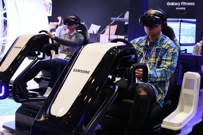 People sit in Samsung racing car simulator as they try out Racing VR at the 2019 Consumer Electronics Show (CES) at the Las Vegas Convention Center on Tuesday, Jan. 8, 2019, in Las Vegas, Nevada. Racing VR is a VR program with the VR simulator. According People sit in Samsung racing car simulator as they try out Racing VR at the 2019 Consumer Electronics Show (CES) at the Las Vegas Convention Center on Tuesday, Jan. 8, 2019, in Las Vegas, Nevada. Racing VR is a VR program with the VR simulator. According