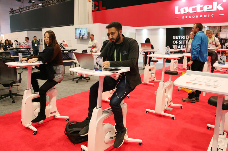 People work on Loctek Deskcise Pro V9 part desk part exercise bike during the 2019 Consumer Electronics Show (CES) at the Las Vegas Convention Center on Tuesday, Jan. 8, 2019, in Las Vegas, Nevada. People work on Loctek Deskcise Pro V9 part desk part exercise bike during the 2019 Consumer Electronics Show (CES) at the Las Vegas Convention Center on Tuesday, Jan. 8, 2019, in Las Vegas, Nevada.