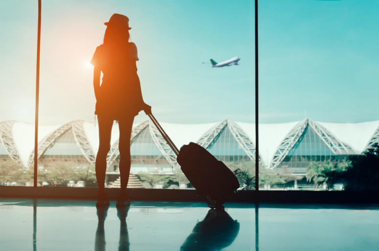 Fashionably Flying Silhouette woman travel with luggage looking without window at airport terminal international or girl teenager traveling in vacation