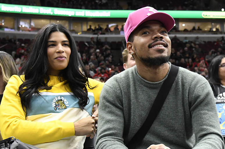 In this Nov. 26, 2018 file photo, Chance the Rapper, right, and Kirsten Corley appear during the second half of an NBA basketball game between the Chicago Bulls and the San Antonio Spurs in Chicago. Chance_the_Rapper