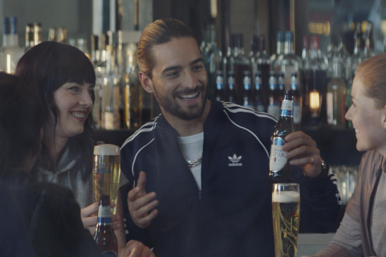 This undated image provided by Michelob ULTRA shows a scene from the company's 2019 Super Bowl NFL football spot featuring Maluma, center. In the ad for Michelob Ultra, a robot beats humans at different sports like running and spinning. But then he looks This undated image provided by Michelob ULTRA shows a scene from the company's 2019 Super Bowl NFL football spot featuring Maluma, center. In the ad for Michelob Ultra, a robot beats humans at different sports like running and spinning. But then he looks