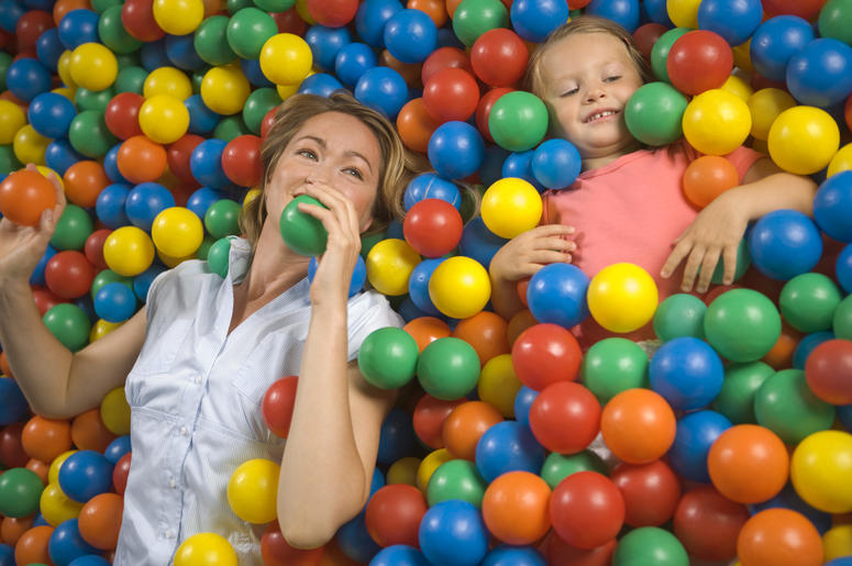 High angle view of a girl with a mid adult woman lying in a ball pool High angle view of a girl with a mid adult woman lying in a ball pool