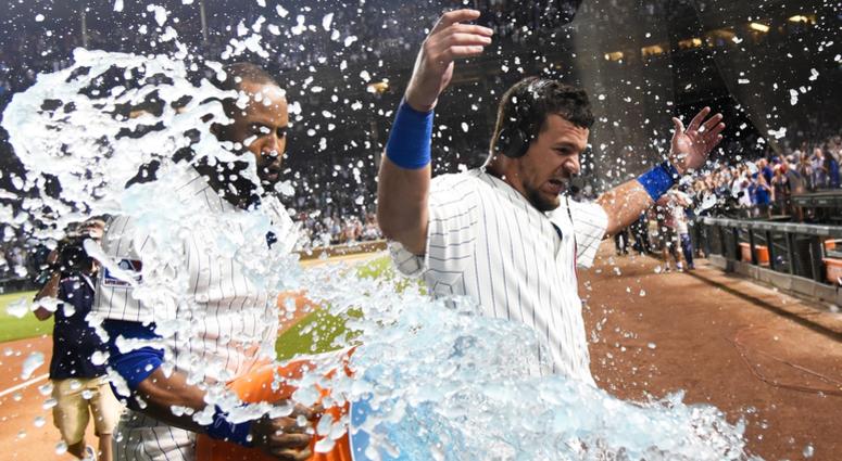 Cubs outfielder Kyle Schwarber is doused after hitting a walk-off homer against the Reds. Cubs outfielder Kyle Schwarber is doused after hitting a walk-off homer against the Reds.