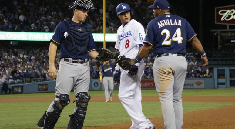 Brewers first baseman Jesus Aguilar (24) takes issues with Dodgers shortstop Manny Machado (8) after Machado clipped Aguilar's foot on a play at first base. Brewers first baseman Jesus Aguilar (24) takes issues with Dodgers shortstop Manny Machado (8) after Machado clipped Aguilar's foot on a play at first base.