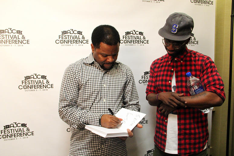 Rap-A-Lot Records founder J. Prince signs a copy of his book for producer Bryan-Michael Cox at A3C in Atlanta on October 4, 2018 Rap-A-Lot Records founder J. Prince signs a copy of his book for producer Bryan-Michael Cox at A3C in Atlanta on October 4, 2018