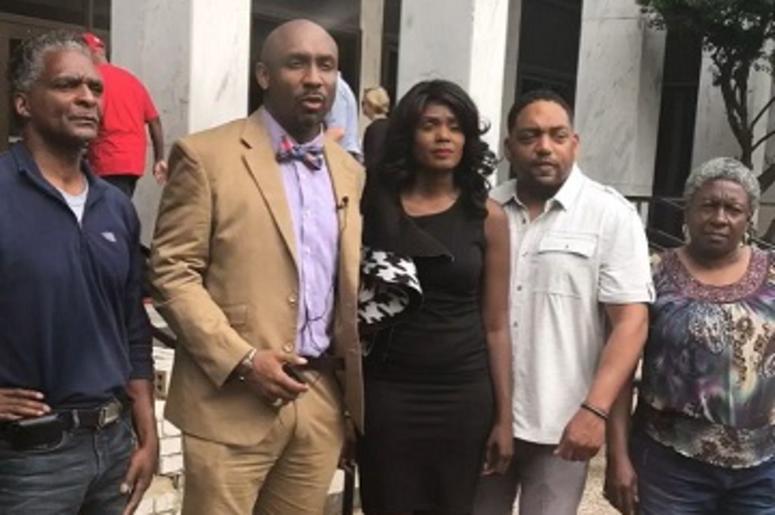 GA State Senate candidate Sabrina McKenzie is joined by Civil Rights attorney Mawuli Davis and others Friday outside the DeKalb County Courthouse