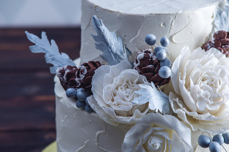 Delicate white bunk wedding cake decorated with an original design using mastic roses Delicate white bunk wedding cake decorated with an original design using mastic roses